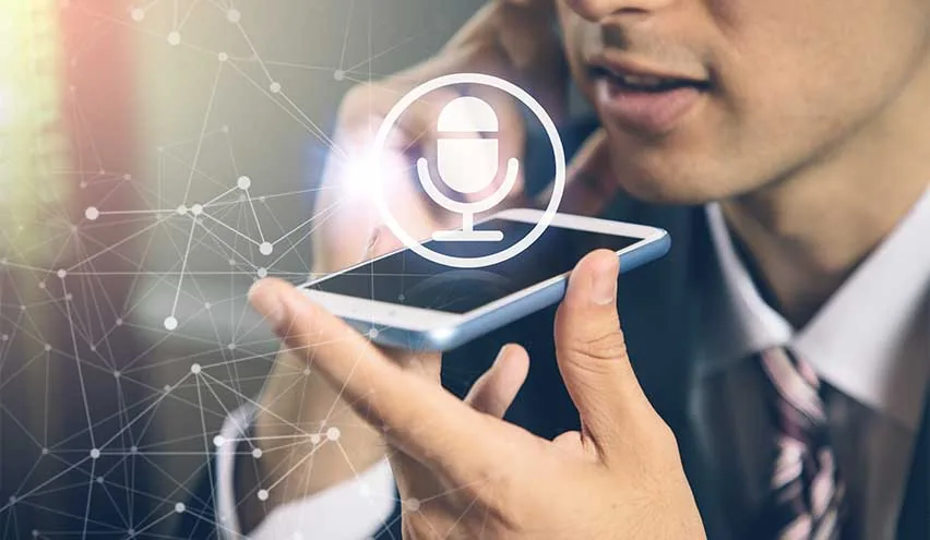 A businessman speaking into a smartphone held near his mouth, with a glowing voice-recognition microphone icon and a network of connected nodes overlaid