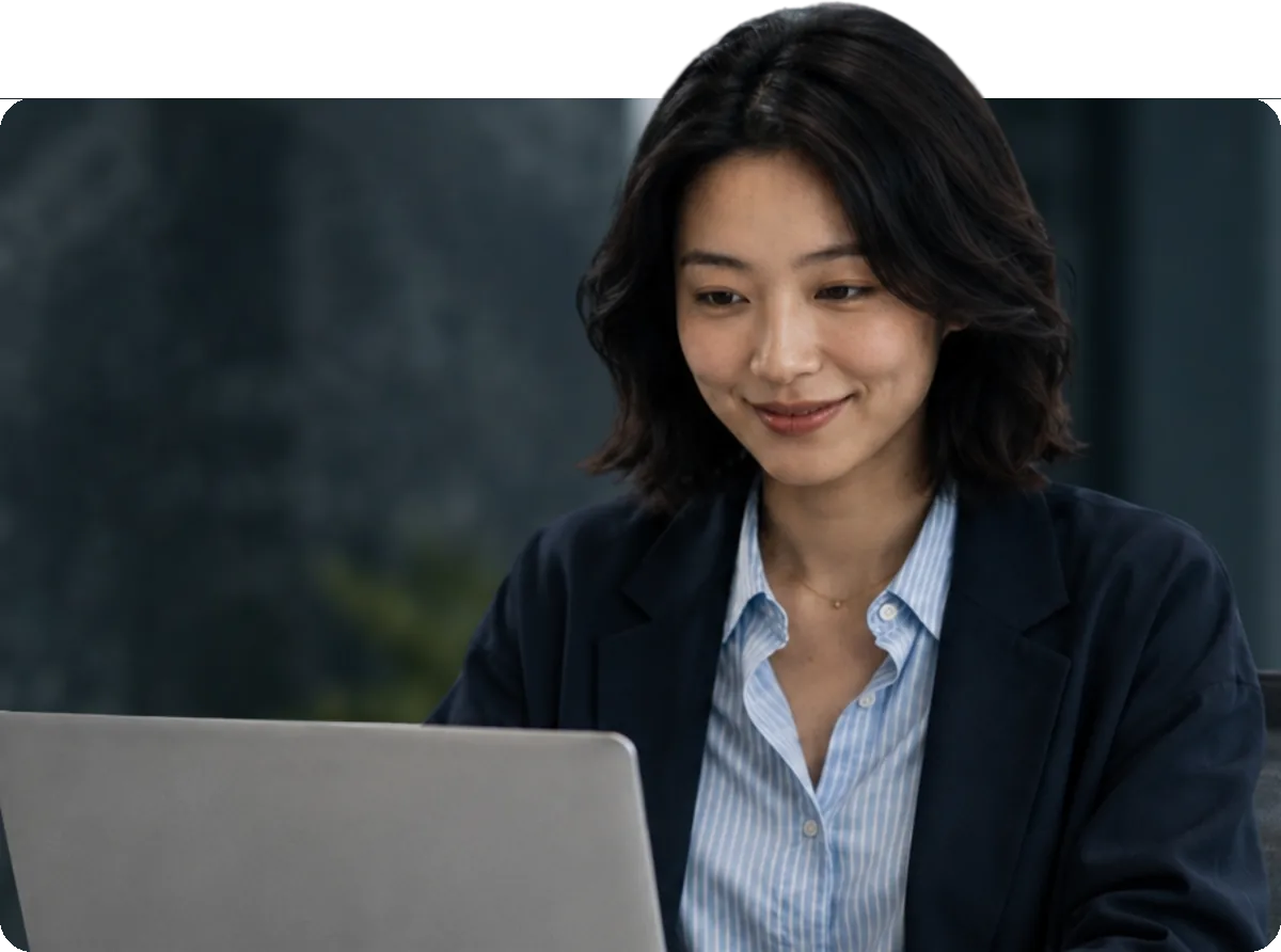 A professional working on a laptop at a desk in a modern office