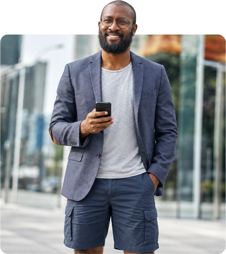 A smiling man in a blazer holding his phone, leaning out of the picture frame